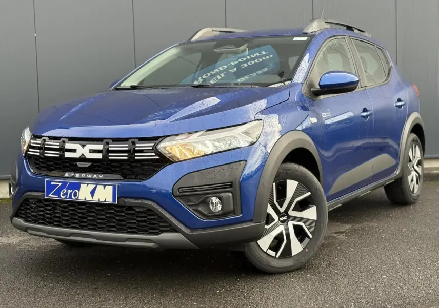 Dacia Sandero Stepway TCE 90 bleu Iron en 3/4 avant droit, avec barres de toit et jantes spécifiques Atara Dark.