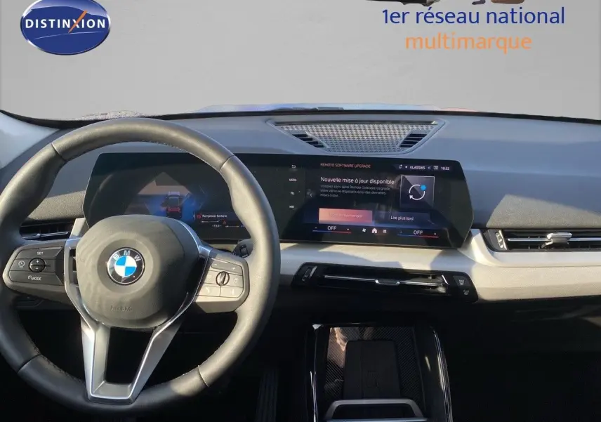 Vue intérieure du tableau de bord et volant BMW X1 2024, avec écran tactile et finition sobre en gris et noir.
