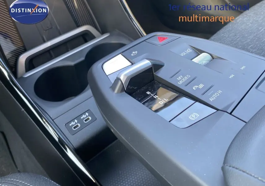 Gros plan sur la console centrale avec levier de vitesses et commandes du BMW X1 18I bleu Phytonic 2024.