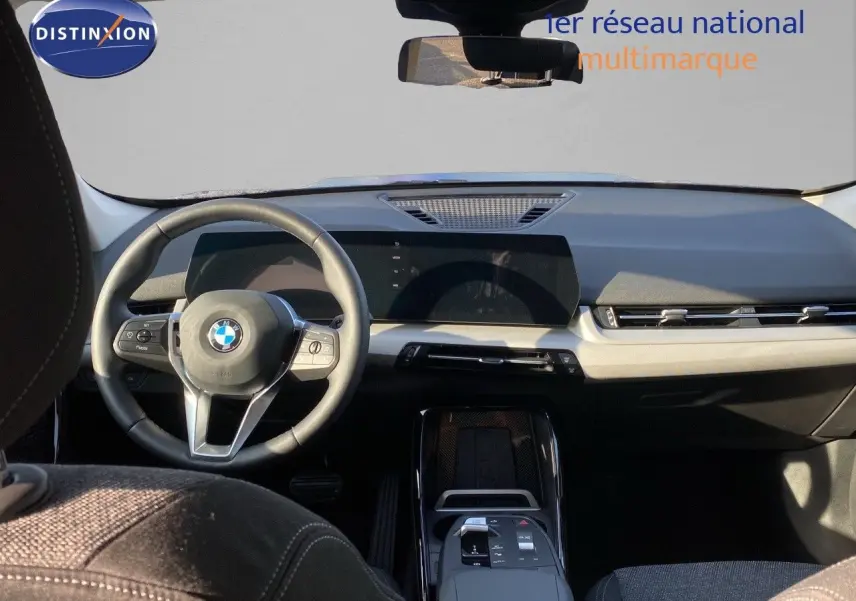 Intérieur du BMW X1 18I 136CH 2024, vue frontale du tableau de bord et volant avec finition sobre et moderne.