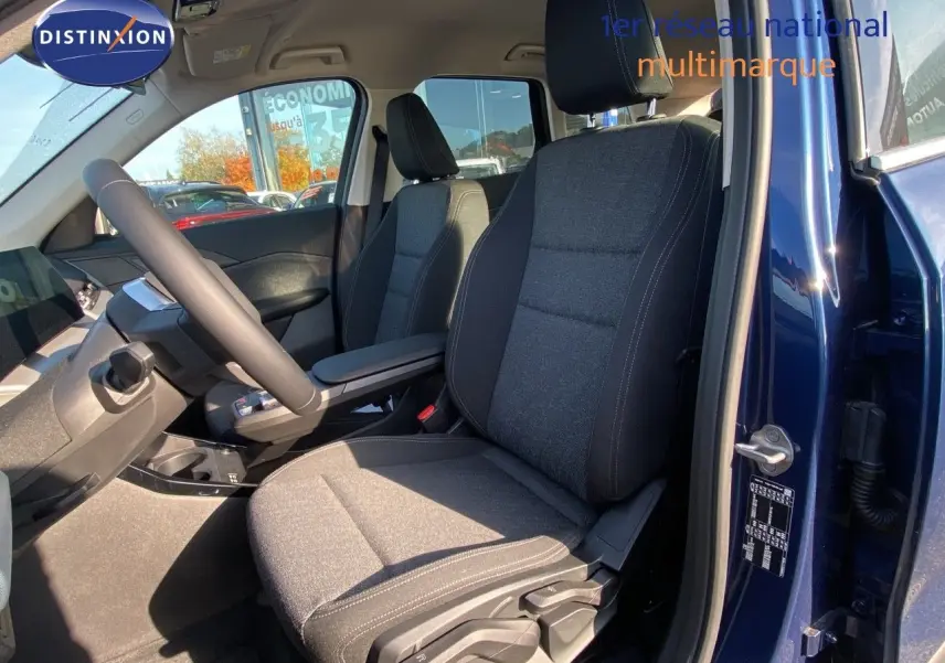 Vue intérieure côté conducteur du BMW X1 18I bleu Phytonic avec sièges tissu gris et tableau de bord moderne.