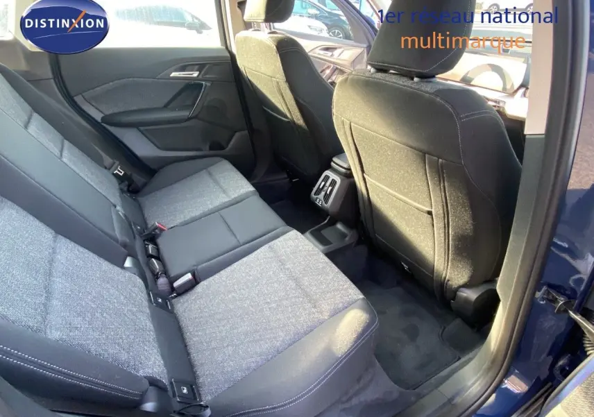 Vue intérieure arrière droite du BMW X1 18I 136CH bleu Phytonic avec sièges tissu gris et noir.