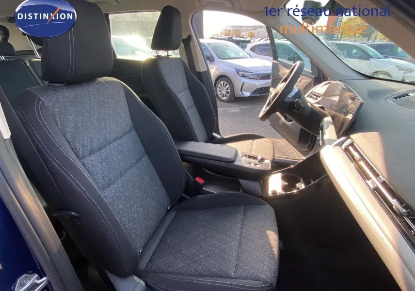 Vue intérieure côté conducteur du BMW X1 18I 136CH avec sièges tissu gris noir et tableau de bord moderne.