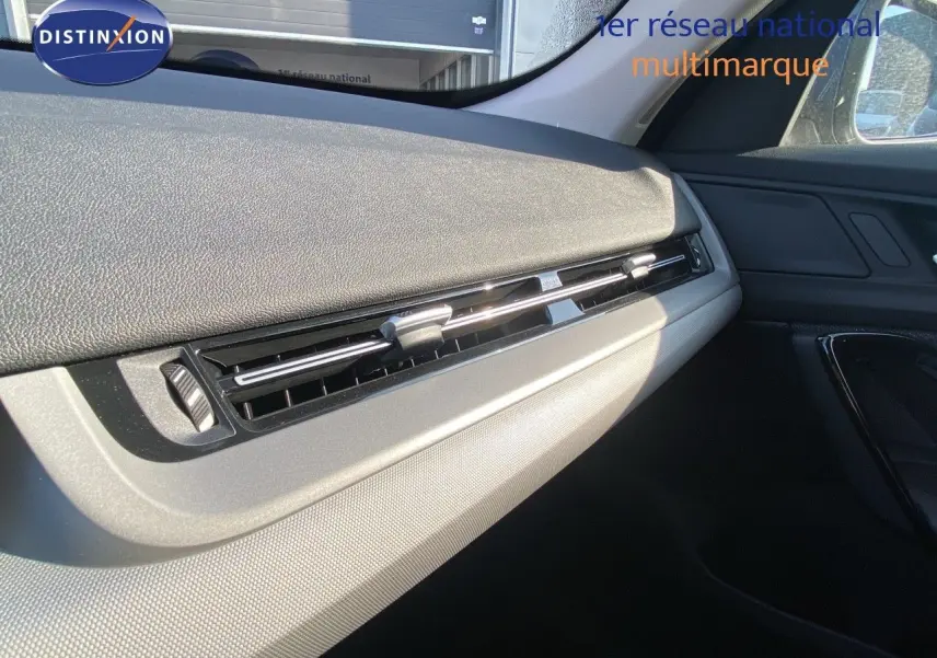 Détail de la partie droite du tableau de bord du BMW X1 18I 136CH bleu Phytonic Metal, avec aérateurs horizontaux.