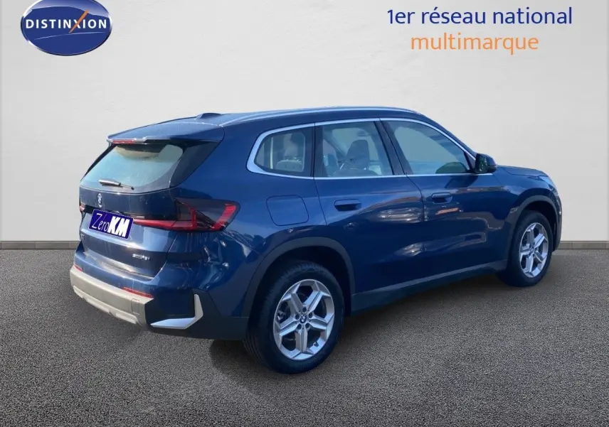 BMW X1 18I 136CH bleu Phytonic Metal en 3/4 arrière droit, mettant en valeur ses lignes modernes et jantes alliage.