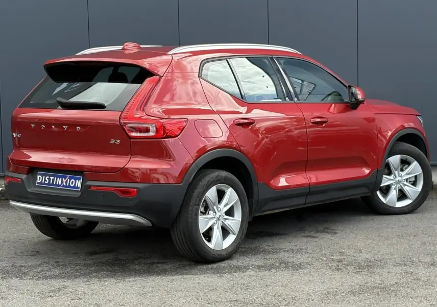 Volvo XC40 B3 MHEV rouge Fusion vue 3/4 arrière droit, avec jantes alliage 18 pouces et toit blanc.