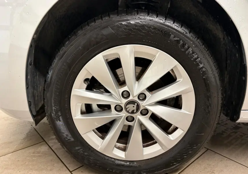 Gros plan sur la roue avant gauche avec jante alliage argentée du Skoda Kamiq gris argent 2025.