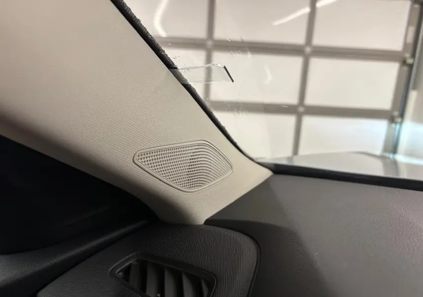 Détail intérieur côté gauche du tableau de bord gris avec haut-parleur intégré sur Skoda Kamiq 2025.