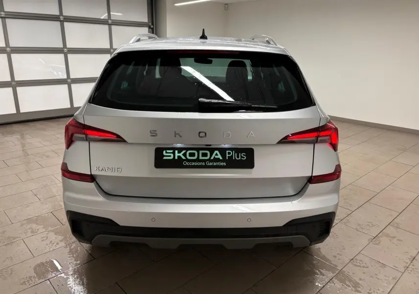 Vue arrière d'un Skoda Kamiq gris argent 2025 avec feux LED et caméra de recul visible sur le pare-chocs.
