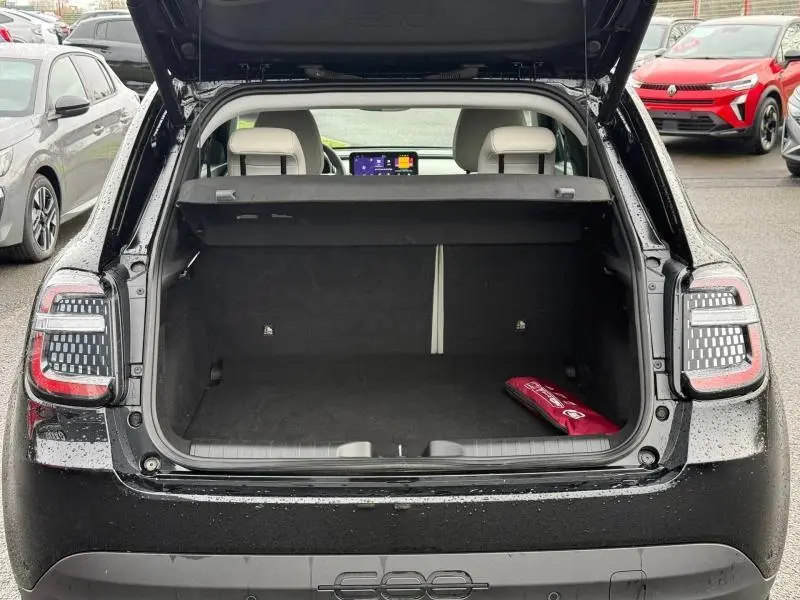 Vue arrière ouverte du coffre noir du FIAT 600 2024 avec banquette arrière et écran tactile visible à l'avant.