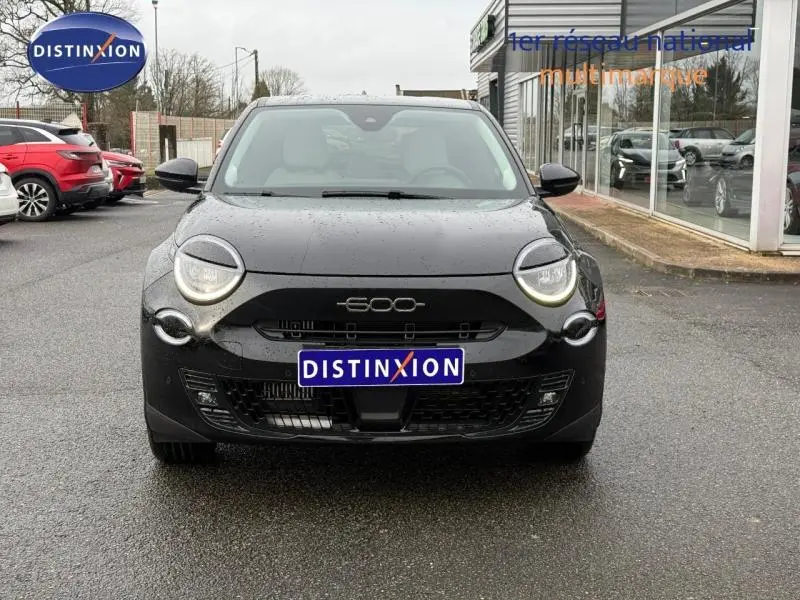 Vue avant d'une FIAT 600 noire 2024 avec phares ronds LED et calandre noire brillante sous la pluie.