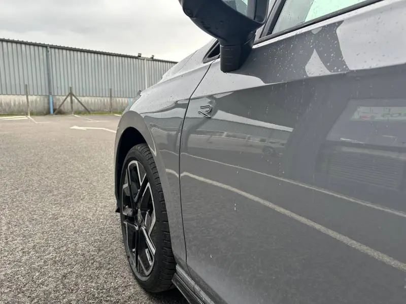 Vue rapprochée côté gauche avant de la Volkswagen Golf 2.0 TDI R-Line gris avec jante noire et logo R sur l'aile.