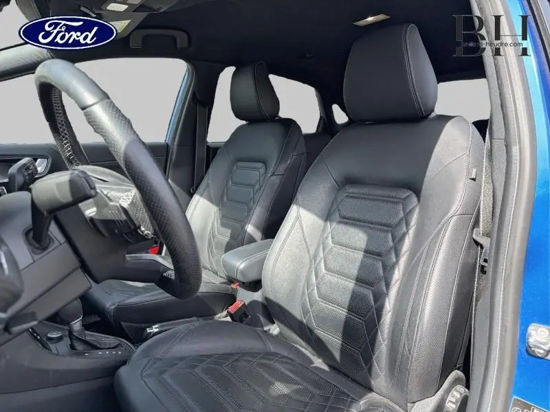 Vue intérieure côté conducteur du Ford Puma bleu, sièges sport en simili cuir noir avec surpiqûres blanches.