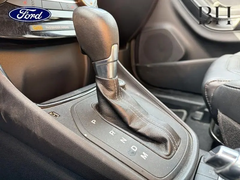 Gros plan sur le levier de vitesses automatique en cuir noir de la Ford Puma 1.0 EcoBoost 2020, intérieur sombre.