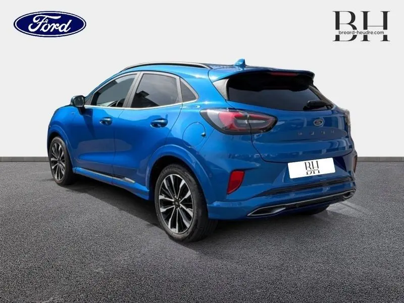 Ford Puma 1.0 EcoBoost bleu métallisé en vue 3/4 arrière droit avec jantes alu et hayon électrique mains libres.