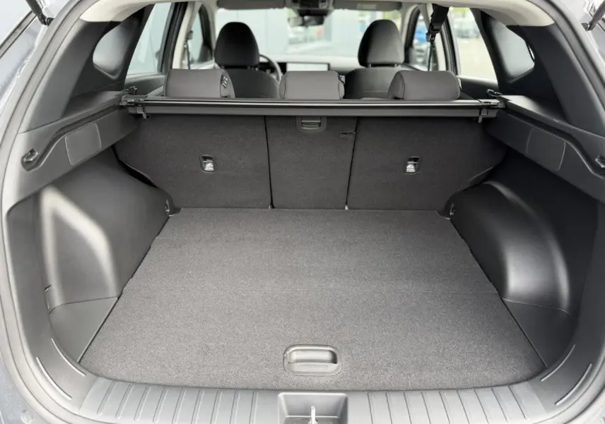 Vue arrière du coffre ouvert d’un Hyundai Tucson gris Ecotronic, montrant l’espace de chargement et la plage arrière.