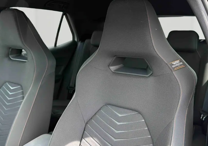Gros plan sur les sièges sport noirs avec surpiqûres contrastées de la CUPRA Born 2024, intérieur épuré et moderne.
