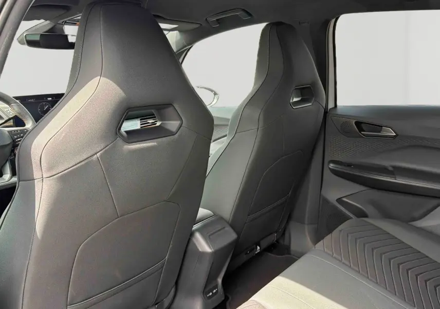 Vue intérieure arrière du CUPRA Born 2024 montrant les sièges avant sport gris et la banquette arrière côté droit.