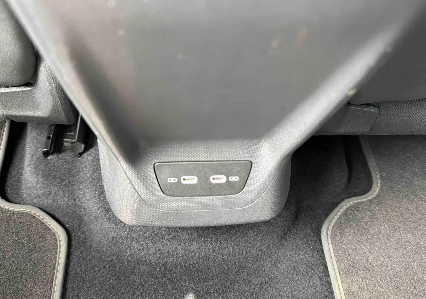 Vue rapprochée des ports USB-C situés à l'arrière de la console centrale du CUPRA Born blanc 2024.