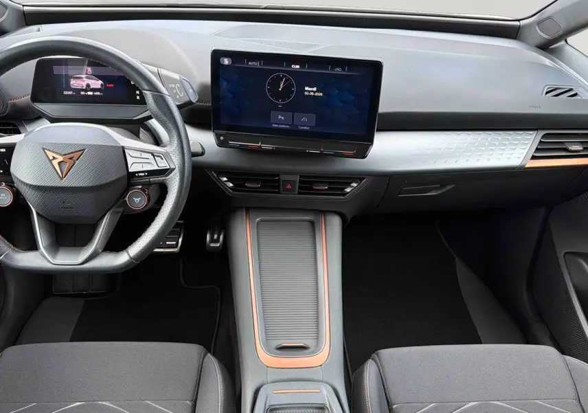 Vue intérieure avant du tableau de bord gris clair et volant multifonction noir avec logo CUPRA en cuivre du Born e-boost 2024.