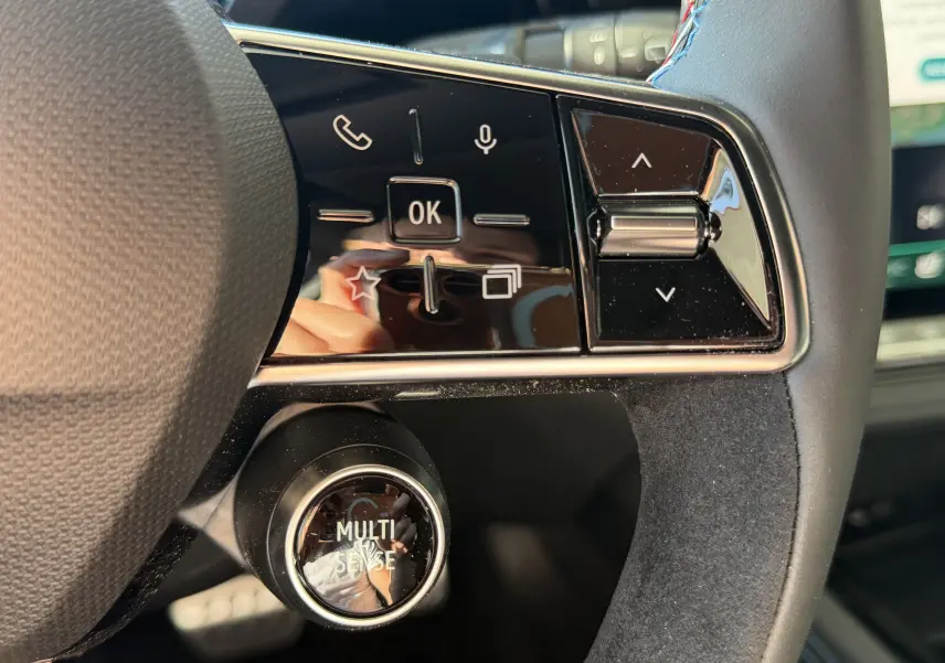 Gros plan sur les commandes du volant noir avec surpiqûres tricolores du Renault Austral E-Tech 200 Esprit Alpine 2026.