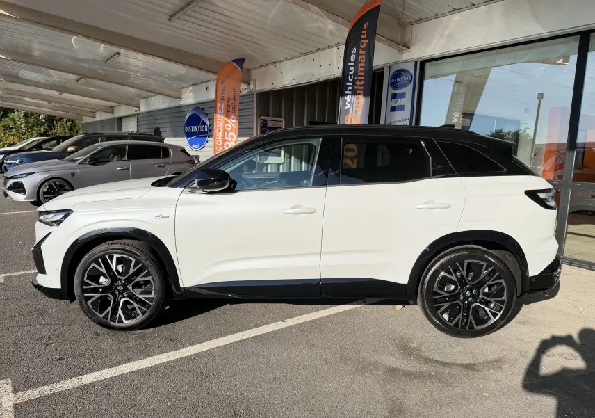 Profil gauche du Renault Austral E-Tech 200 Esprit Alpine blanc nacré avec toit noir et jantes 20 pouces noires.