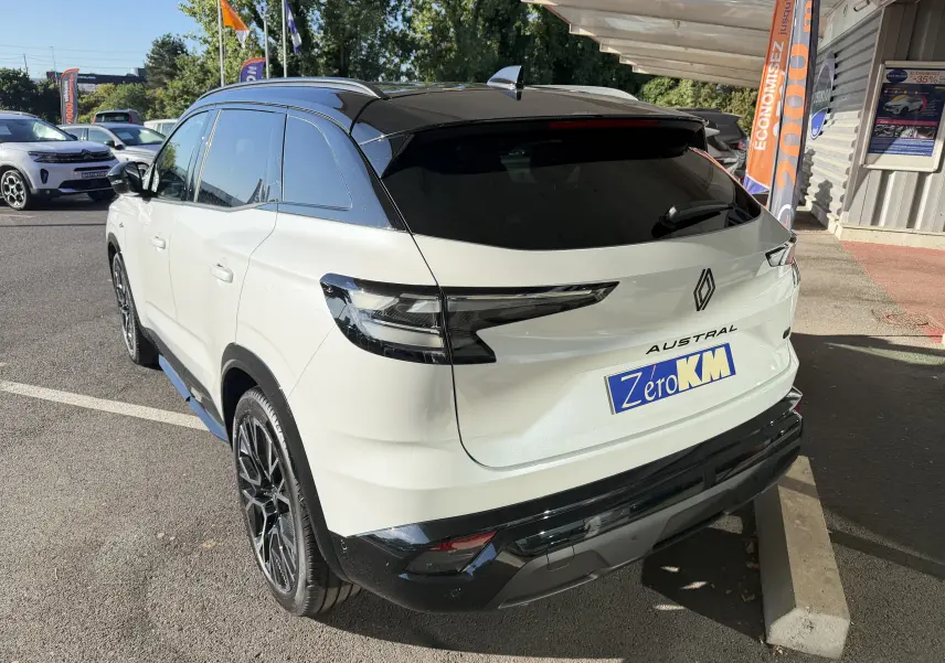 Vue 3/4 arrière d’un Renault Austral E-Tech blanc nacré avec toit noir, jantes 20 pouces et feux arrière LED distinctifs.