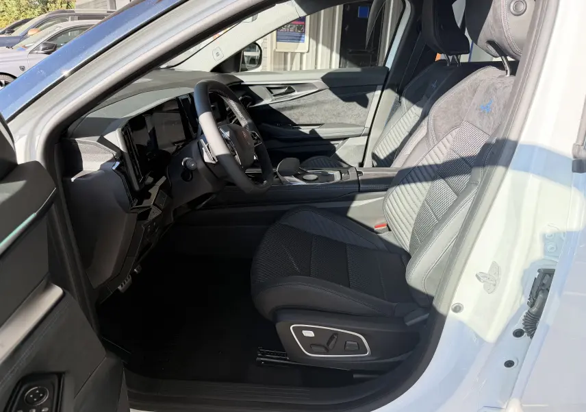 Vue intérieure côté conducteur du Renault Austral E-Tech 200 Esprit Alpine blanc nacré, sièges en Alcantara avec logo Alpine brodé.