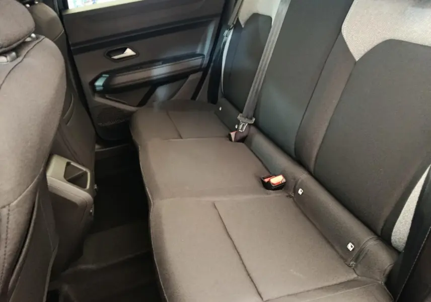 Vue intérieure côté droit sur la banquette arrière noire du Dacia Duster Journey Hybrid 155, avec ceinture et fixation Isofix visibles.