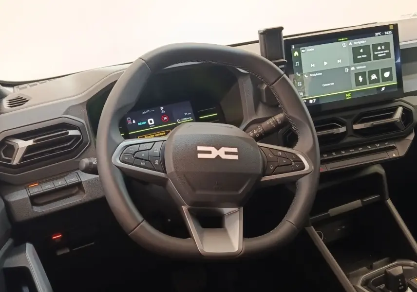 Vue intérieure du tableau de bord du Dacia Duster Journey Hybrid 155 2026 avec volant multifonctions et écran tactile central.