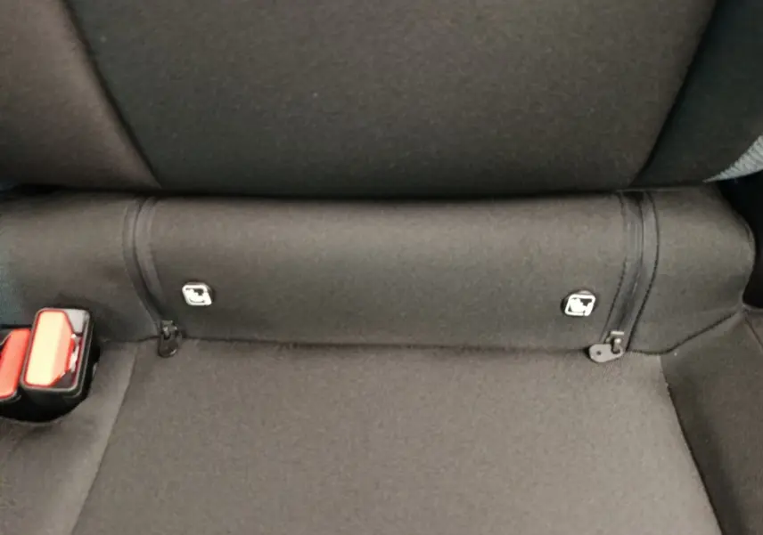 Gros plan sur la banquette arrière noire du Dacia Duster Journey Hybrid 155, avec attaches Isofix visibles.