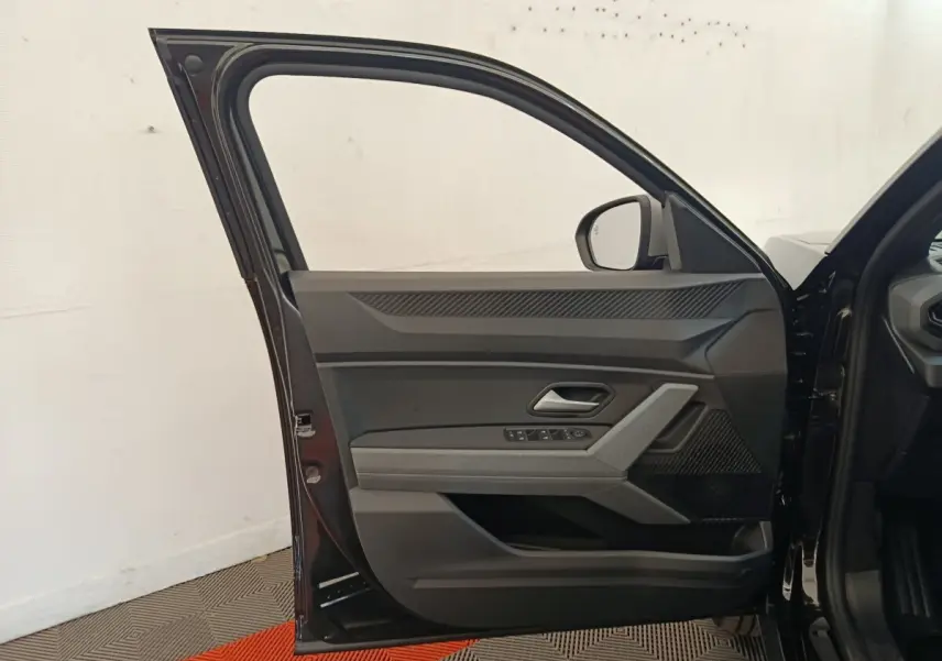 Portière avant gauche ouverte d'un Dacia Duster Journey Hybrid 155 noir, montrant les commandes de vitres et le miroir extérieur.