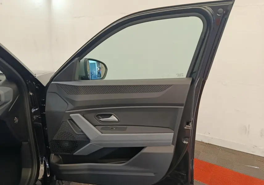 Vue intérieure de la porte avant gauche noire du Dacia Duster Journey Hybrid 155, avec détails des commandes et poignée intégrée.