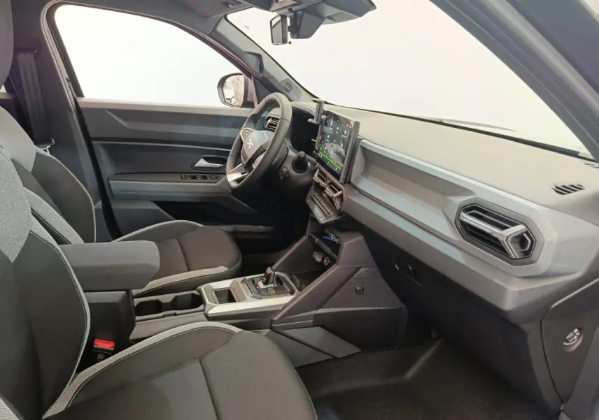 Vue intérieure côté conducteur du Dacia Duster noir 2026, mettant en valeur le tableau de bord moderne avec écran tactile central.