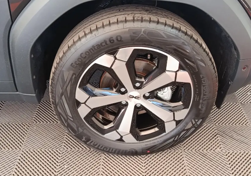 Gros plan sur la roue avant droite du Dacia Duster noir 2026, mettant en valeur la jante alliage bicolore et le pneu Continental.