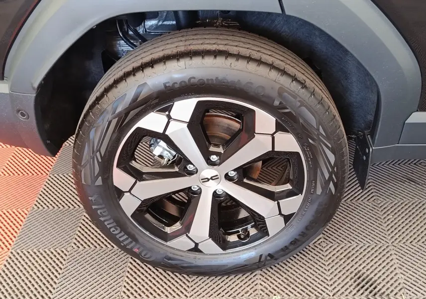 Gros plan sur la roue avant droite du Dacia Duster noir 2026, mettant en valeur la jante alliage bicolore au design moderne.