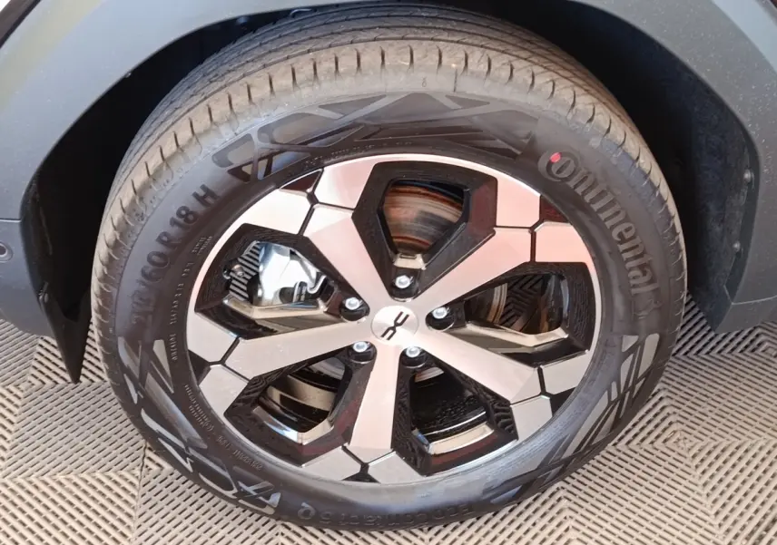 Gros plan sur la roue avant gauche du Dacia Duster Journey Hybrid 155 noir, avec jante alu bicolore et pneu Continental.