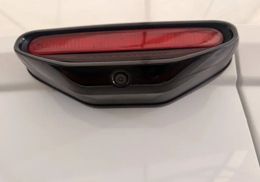 Détail du feu stop et caméra de recul sur la porte arrière blanche d’un Citroën Berlingo 2019.