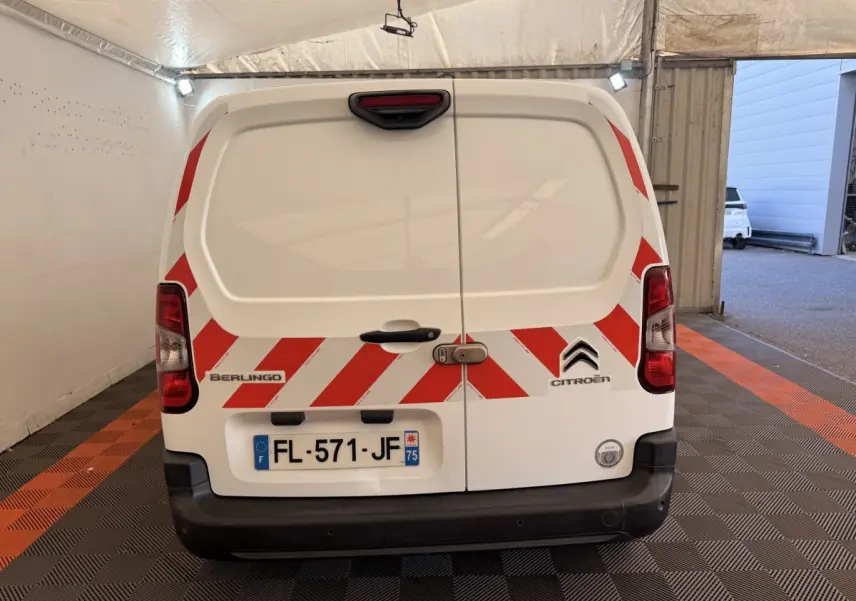 Vue arrière d’un utilitaire Citroën Berlingo blanc de 2019 avec bandes rouges réfléchissantes et plaque d’immatriculation française.