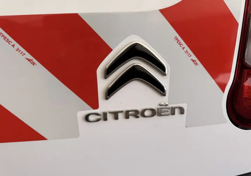 Gros plan sur l'arrière blanc d'un Citroën Berlingo 2019 avec marquage rouge réfléchissant et feu arrière droit visible.