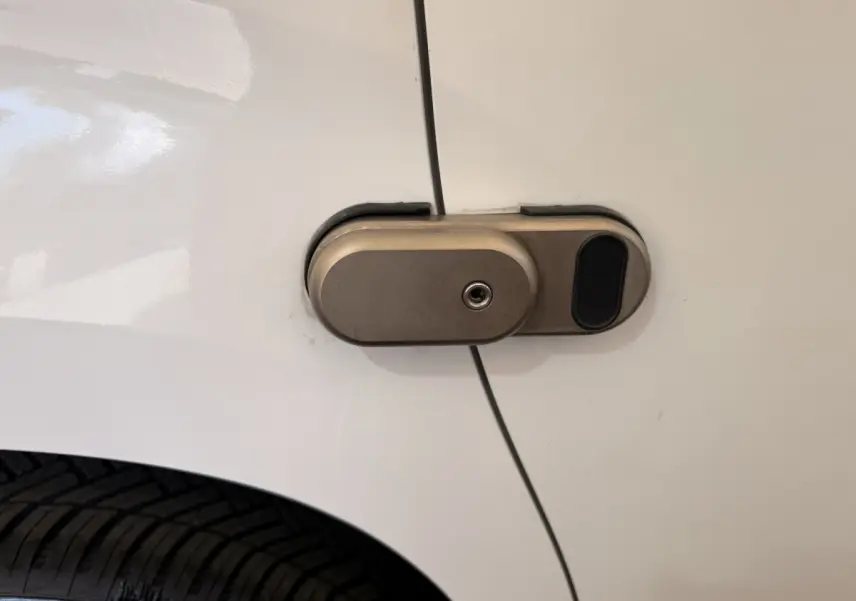 Gros plan sur la serrure métallique de la porte latérale blanche d’un Citroën Berlingo 2019.