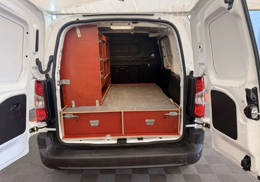 Vue arrière du Citroën Berlingo blanc 2019 avec portes ouvertes, montrant un aménagement bois dans l’espace de chargement.