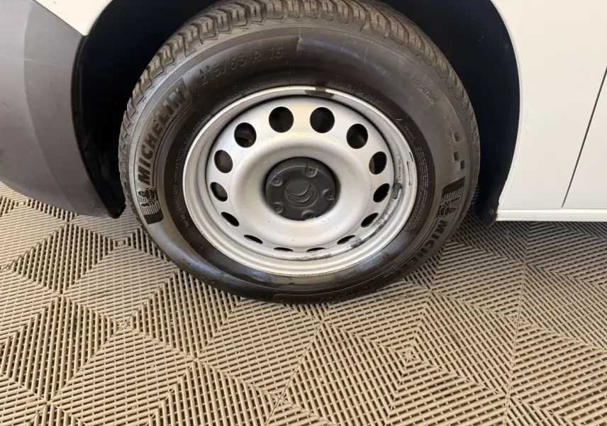 Gros plan sur la roue avant droite d’un Citroën Berlingo blanc 2019 avec jante acier et pneu Michelin.