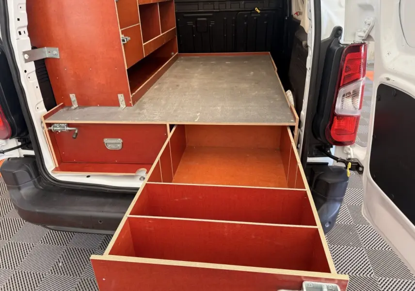 Vue arrière du Citroën Berlingo blanc 2019 avec aménagements en bois rouge et tiroirs ouverts dans la zone de chargement.