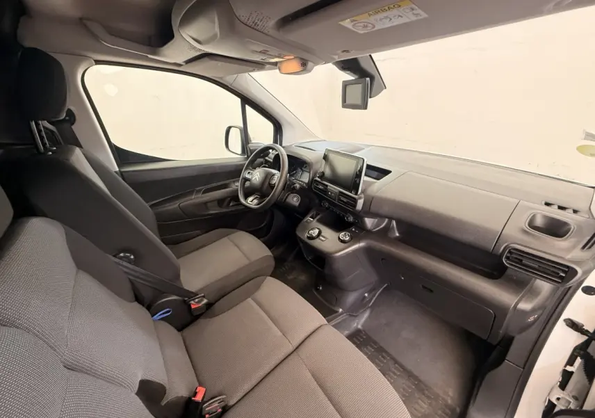 Vue intérieure côté conducteur du Citroën Berlingo blanc 2019, montrant le tableau de bord et les sièges gris.