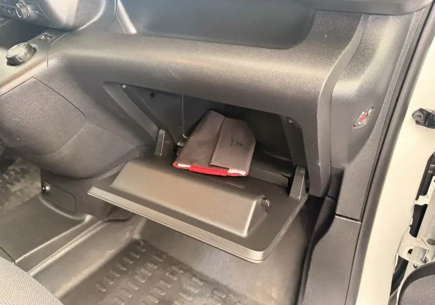 Gant de boîte à gants ouvert côté passager dans un Citroën Berlingo blanc 2019, avec un carnet de bord visible.