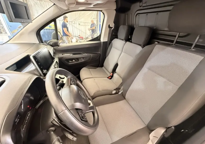 Vue intérieure côté conducteur du Citroën Berlingo 2019, sièges gris et tableau de bord avec écran tactile.