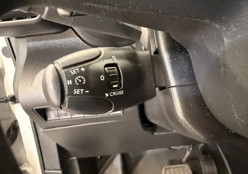 Gros plan sur le commodo de régulateur de vitesse du Citroën Berlingo 2019, intérieur noir avec commandes blanches.