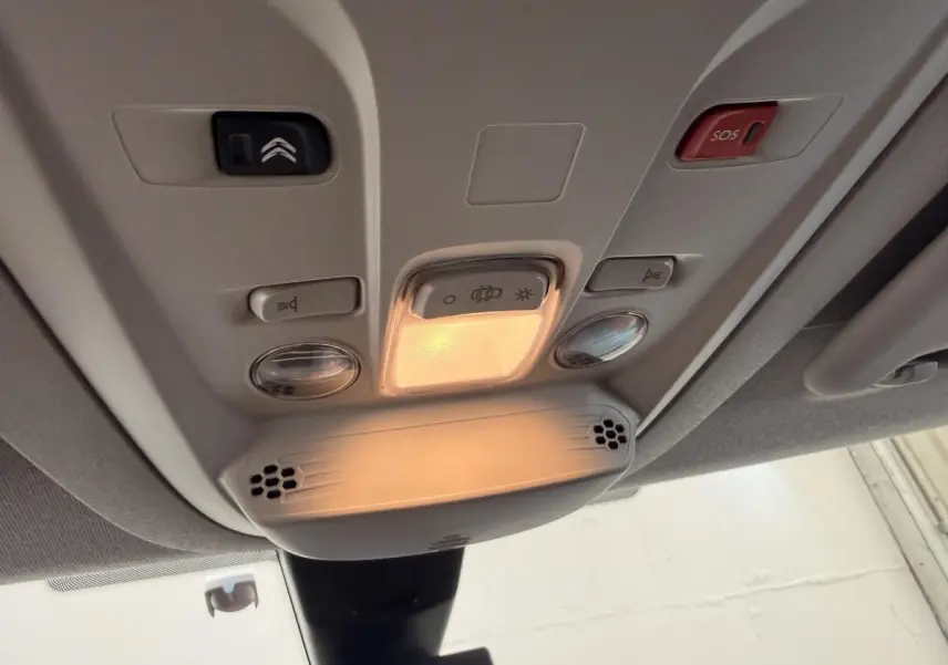 Vue en gros plan du plafonnier intérieur du Citroën Berlingo blanc 2019 avec boutons d’éclairage et alerte SOS.