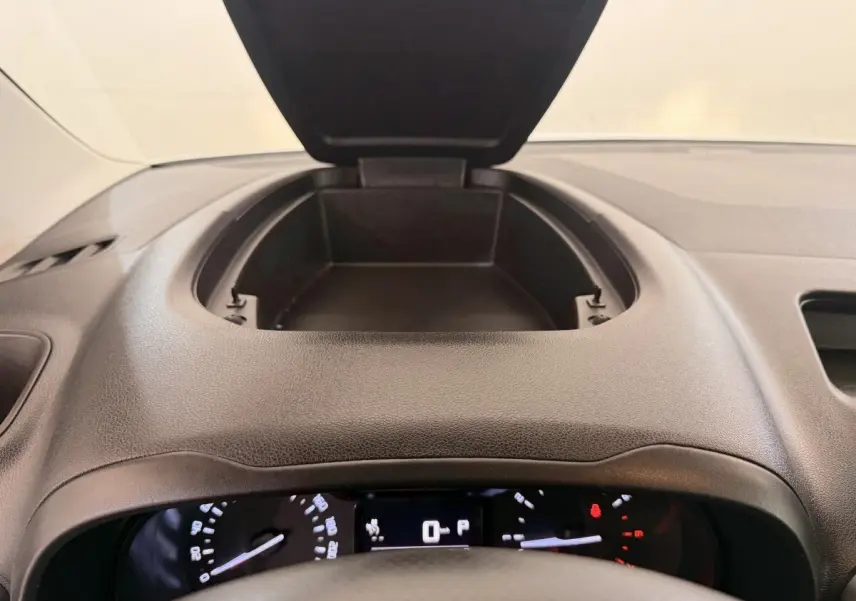 Vue intérieure du tableau de bord noir du Citroën Berlingo 2019, avec rangement ouvert au centre et compteurs visibles.